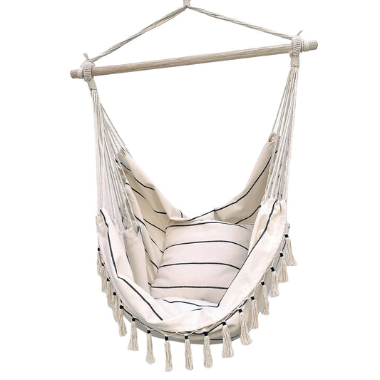 Cream hammock chair with striped seat cushion and long fringe tassels, hanging from bar