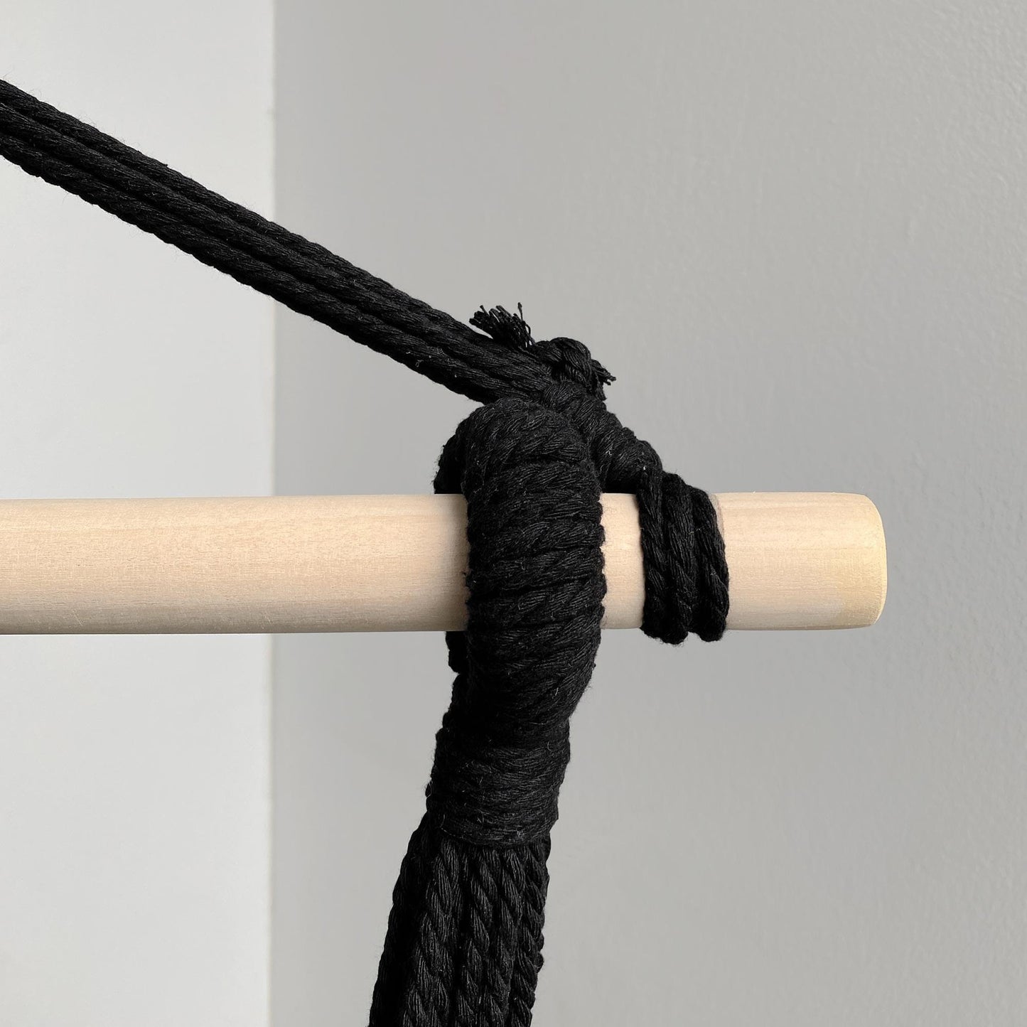 Black hammock suspension rope knot on wooden spreader bar