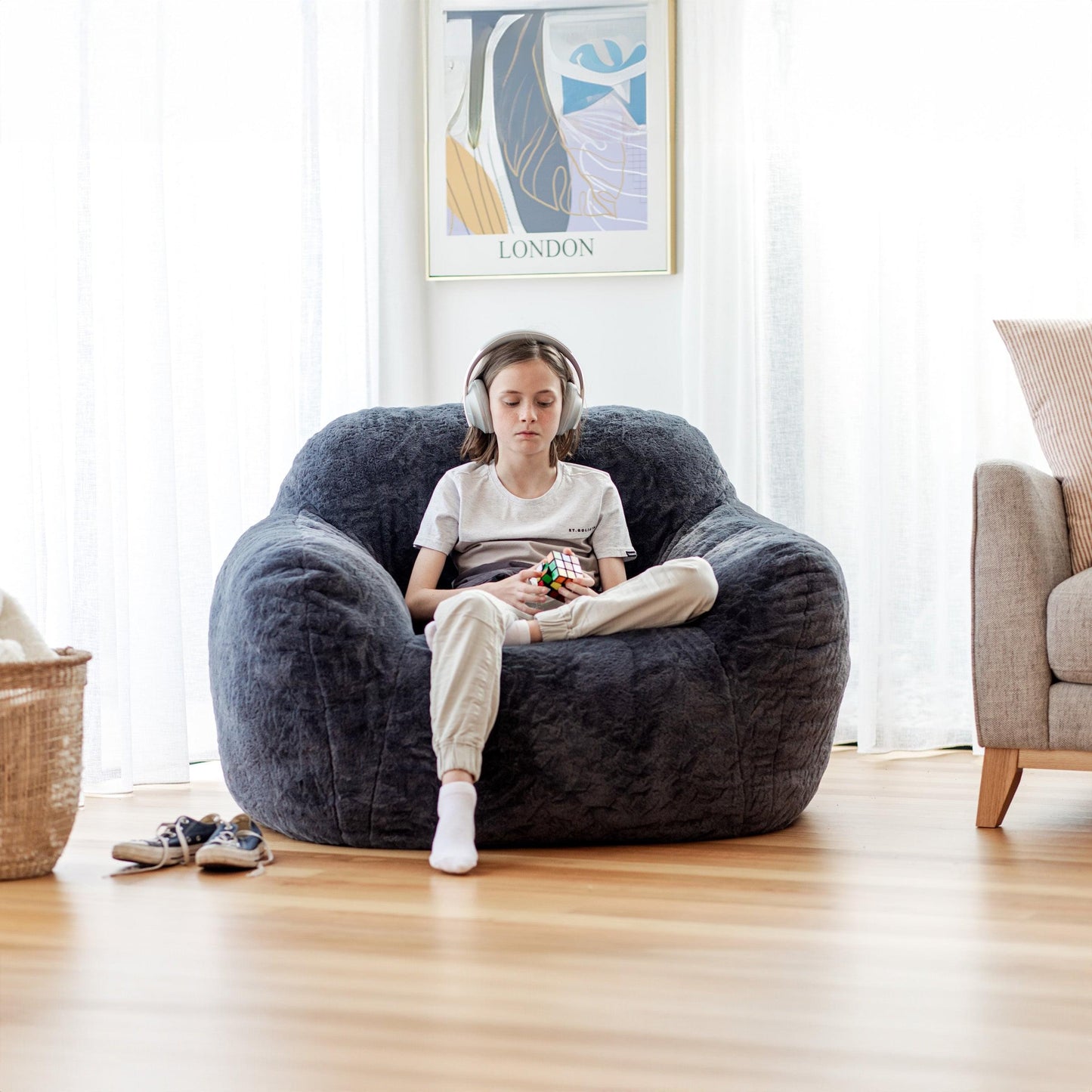 Charcoal gray plush bean bag chair, relaxed oval shape and deep seat