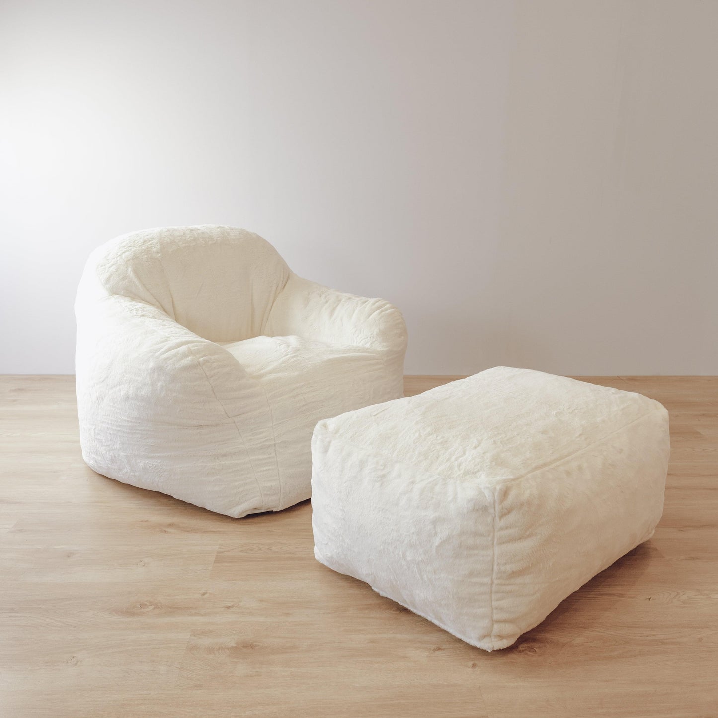 White plush ottomans, one larger and one smaller, shown side by side