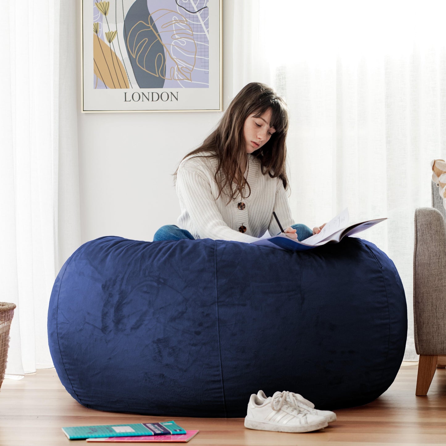 Navy blue large bean bag with plush cover and stitched seams, sitting-ready shape