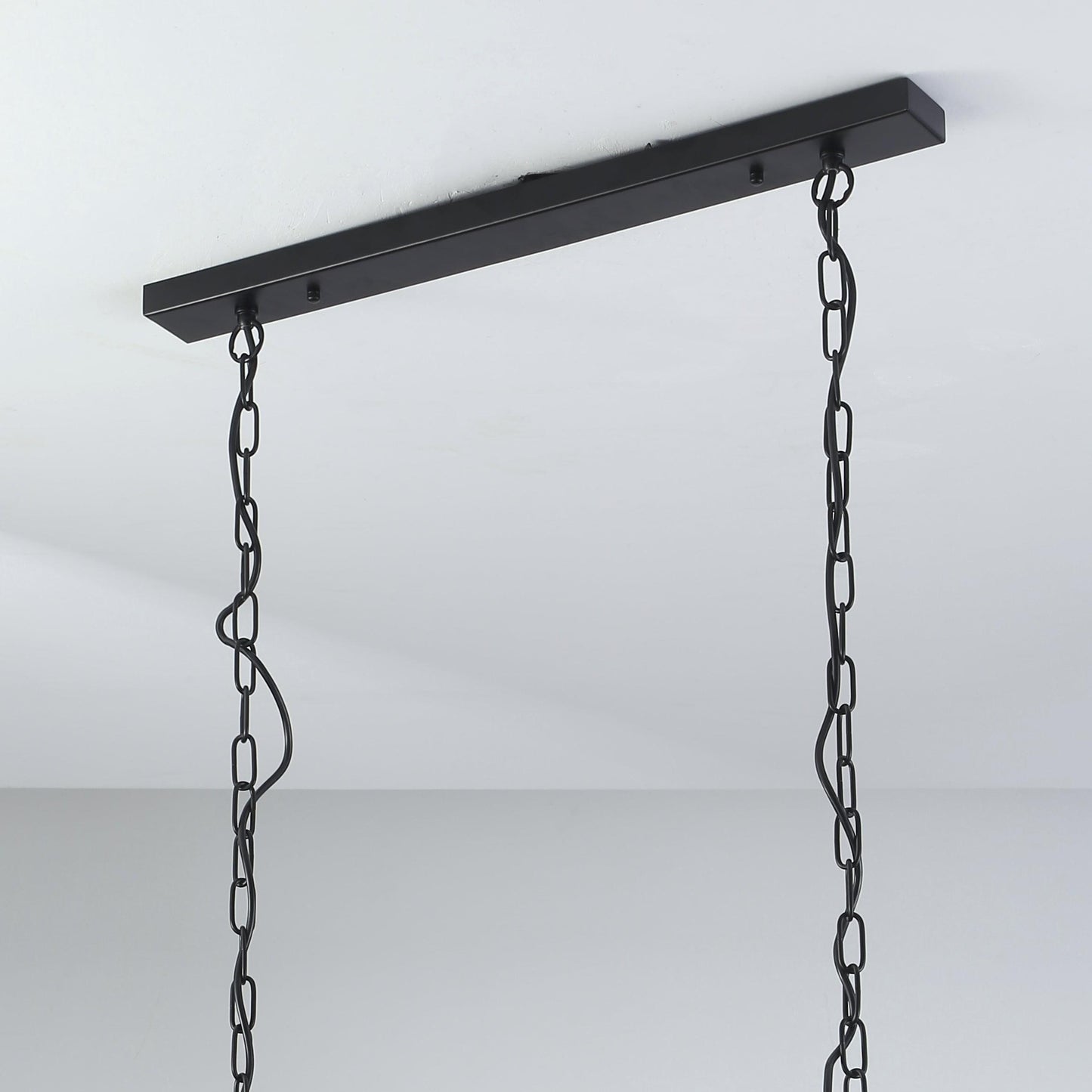 Black ceiling canopy with chain suspension for rectangular pendant light