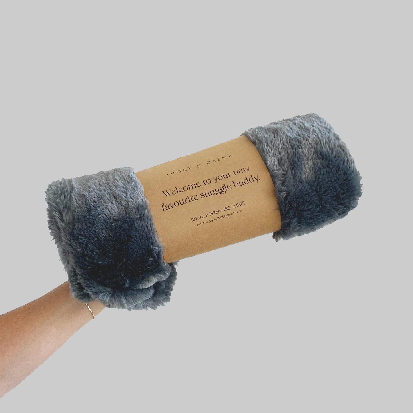Charcoal gray plush throw blanket rolled with fabric tag on band