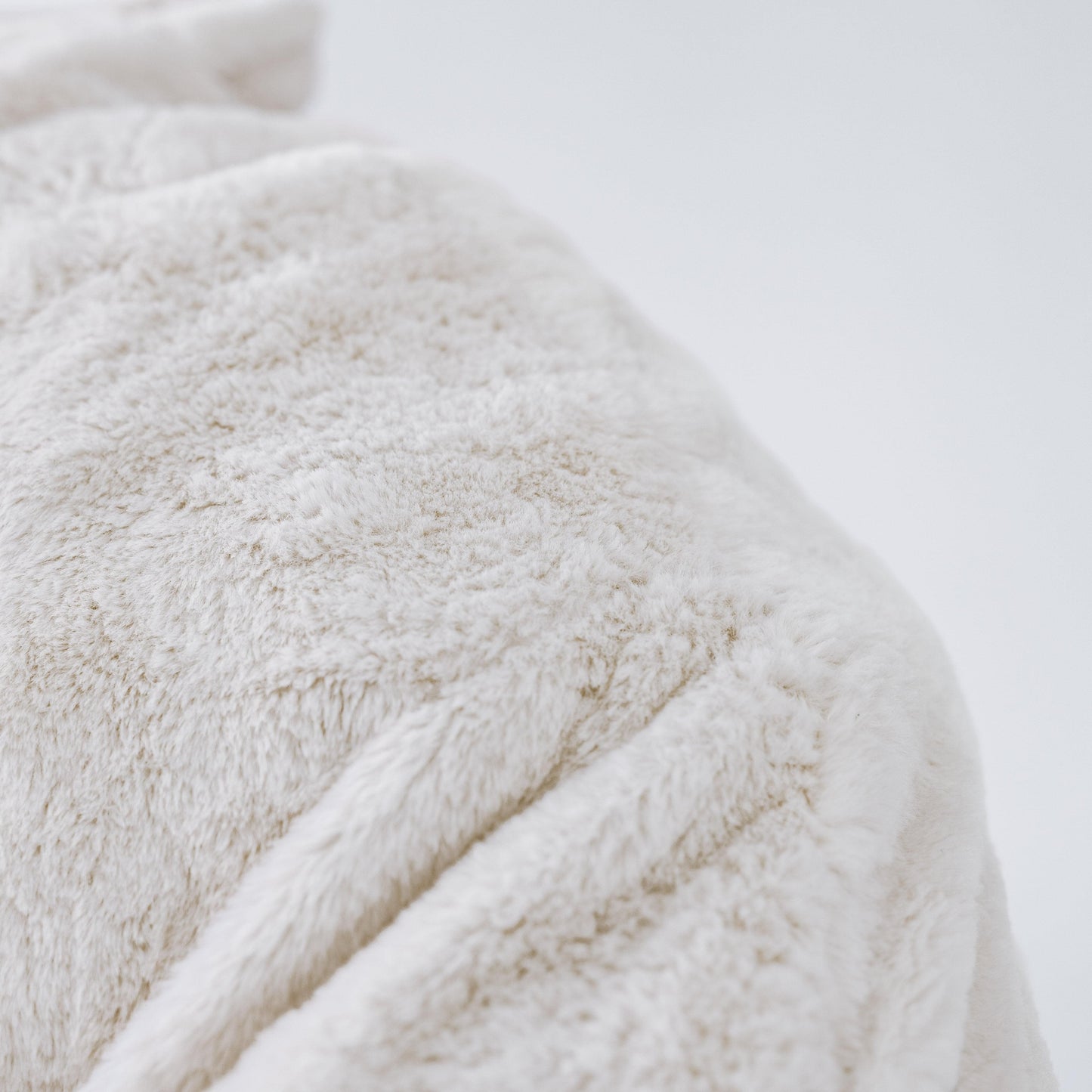 Close-up of white plush mini beanbag chair fabric and stitching