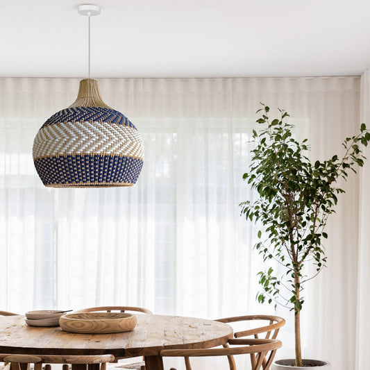 Rattan pendant light hanging above table, blue and white woven globe shade