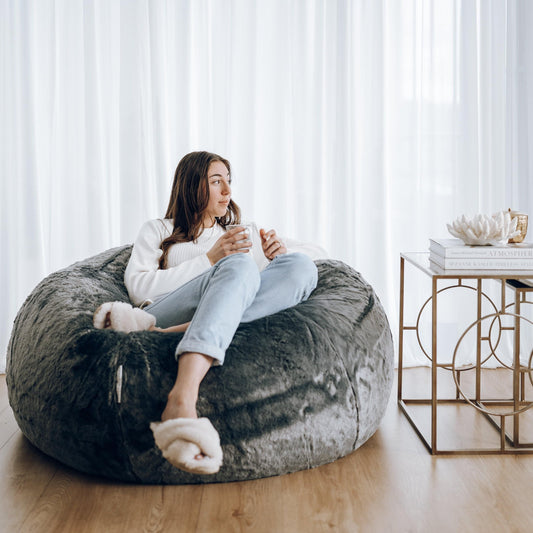 Charcoal plush fur bean bag with large rounded seat, person lounging