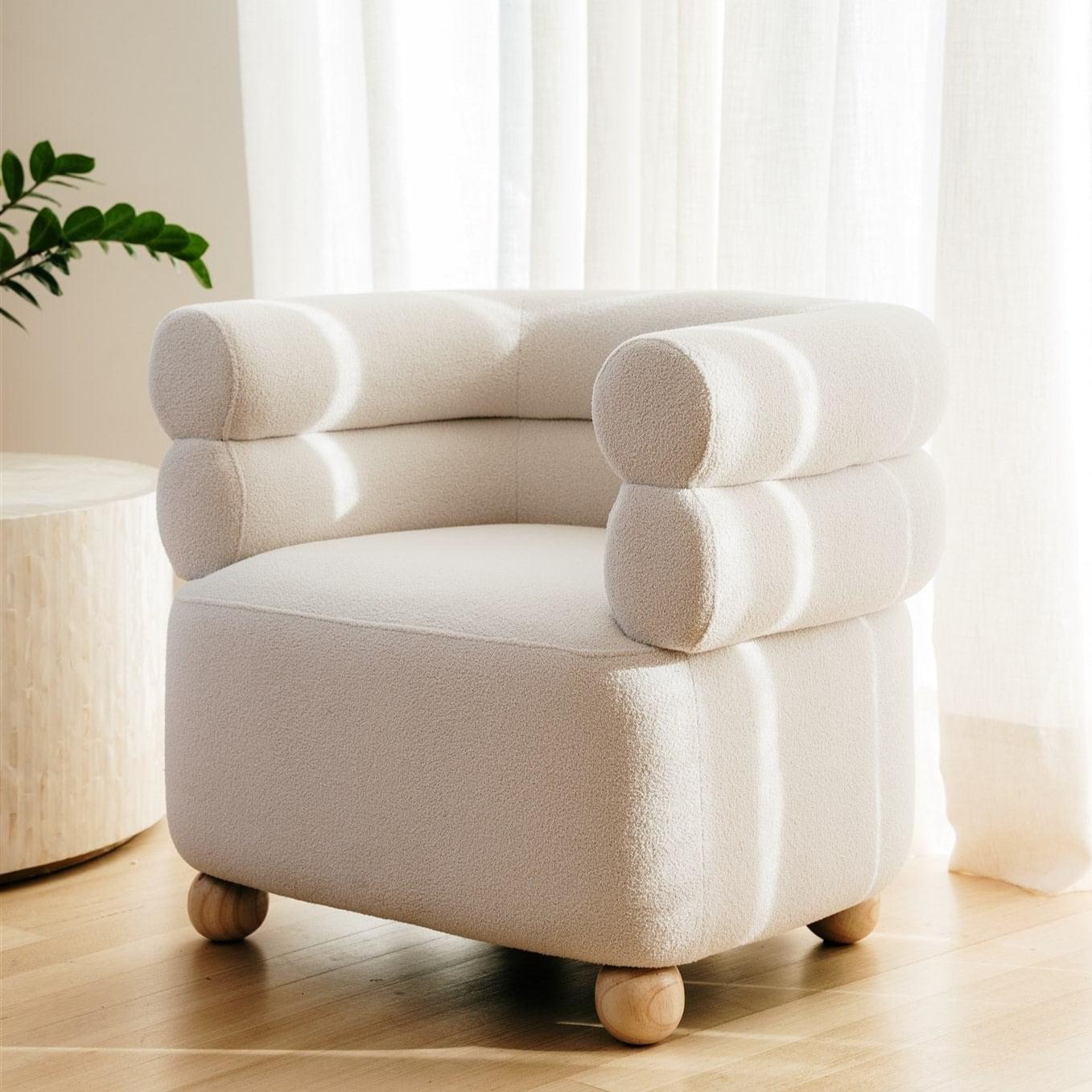 White boucle armchair with rounded arms and back, curved seat, and wooden feet