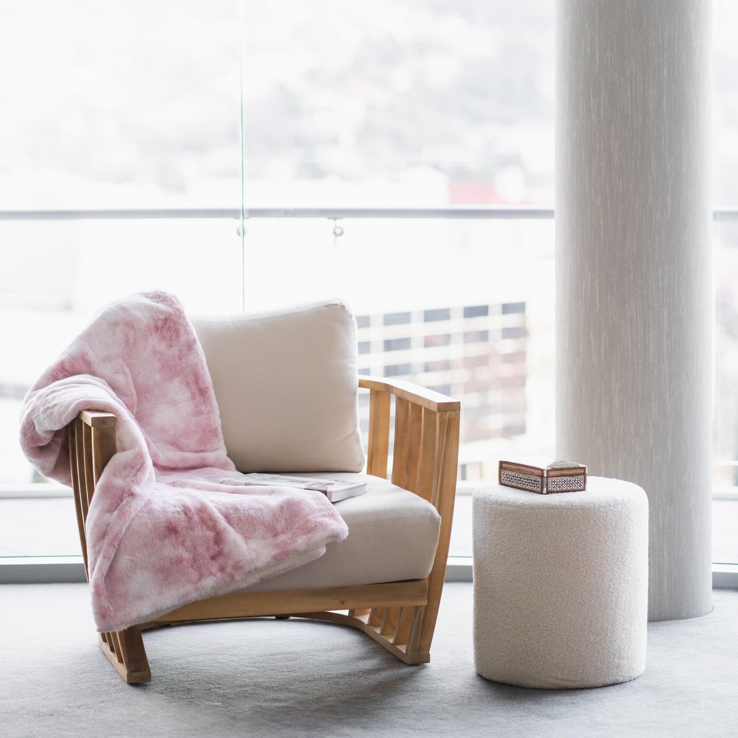 Pink plush faux fur throw blanket folded over armchair