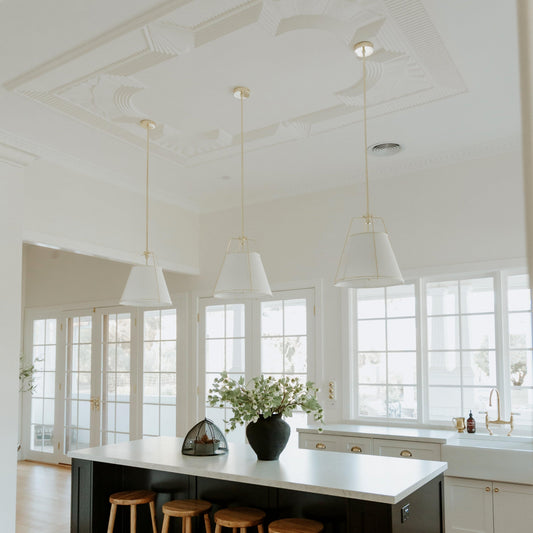 Gold-framed white pendant light with fabric shade and hanging cord mount