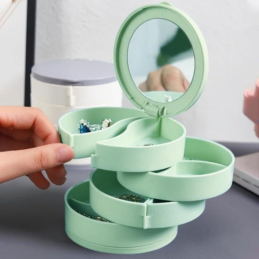 Mint green rotating jewelry box with tiers opened by hand and round mirror