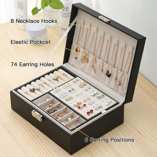 Black jewelry box with open compartments, necklace hooks and earring holders, on tabletop