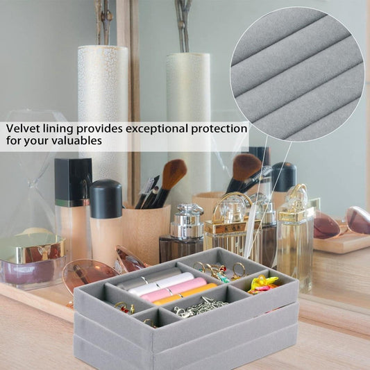 Jewelry drawer organizer with gray velvet-lined compartments, storing earrings and rings
