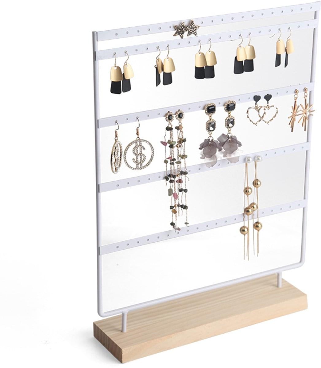 White jewelry stand with 4 tiers and hanging earrings, bracelets, and necklaces on pegs