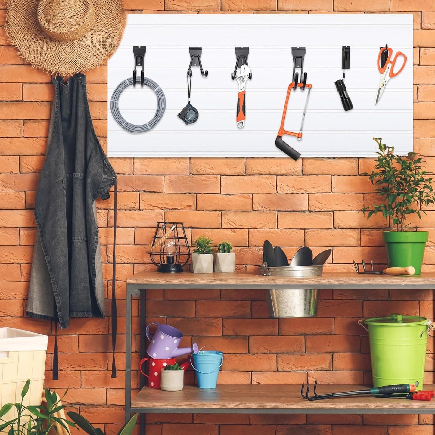 Black slatwall hooks installed on brick wall for hanging coats and tools