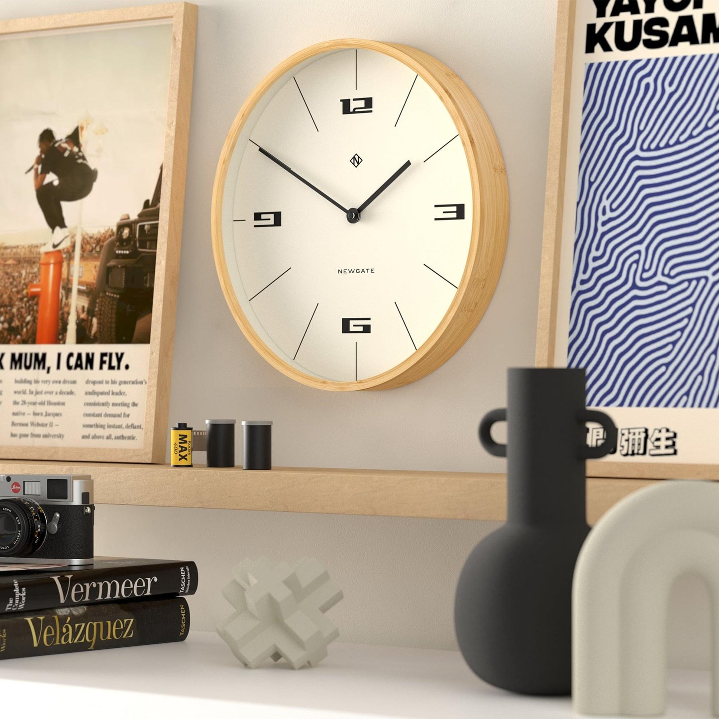 Round wall clock with light wood border and cream dial, black hands and bold hour numerals