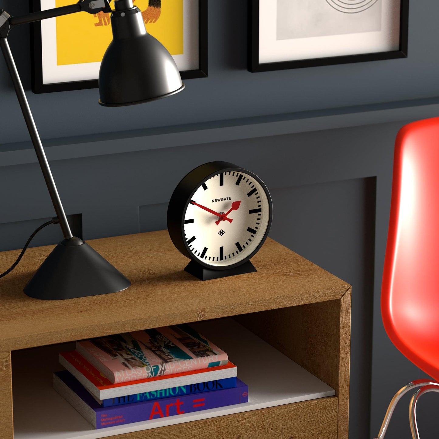 Black round mantel clock with white dial and red hands, standing on small base