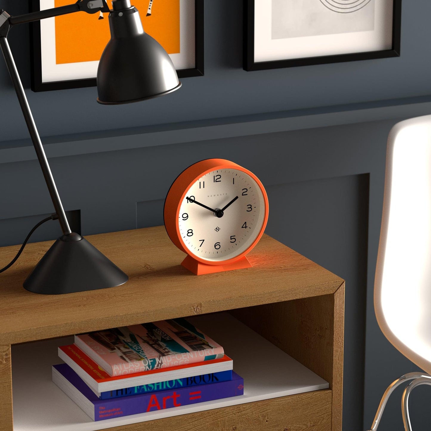 Orange mantel clock on wooden mantle with white dial and black hands