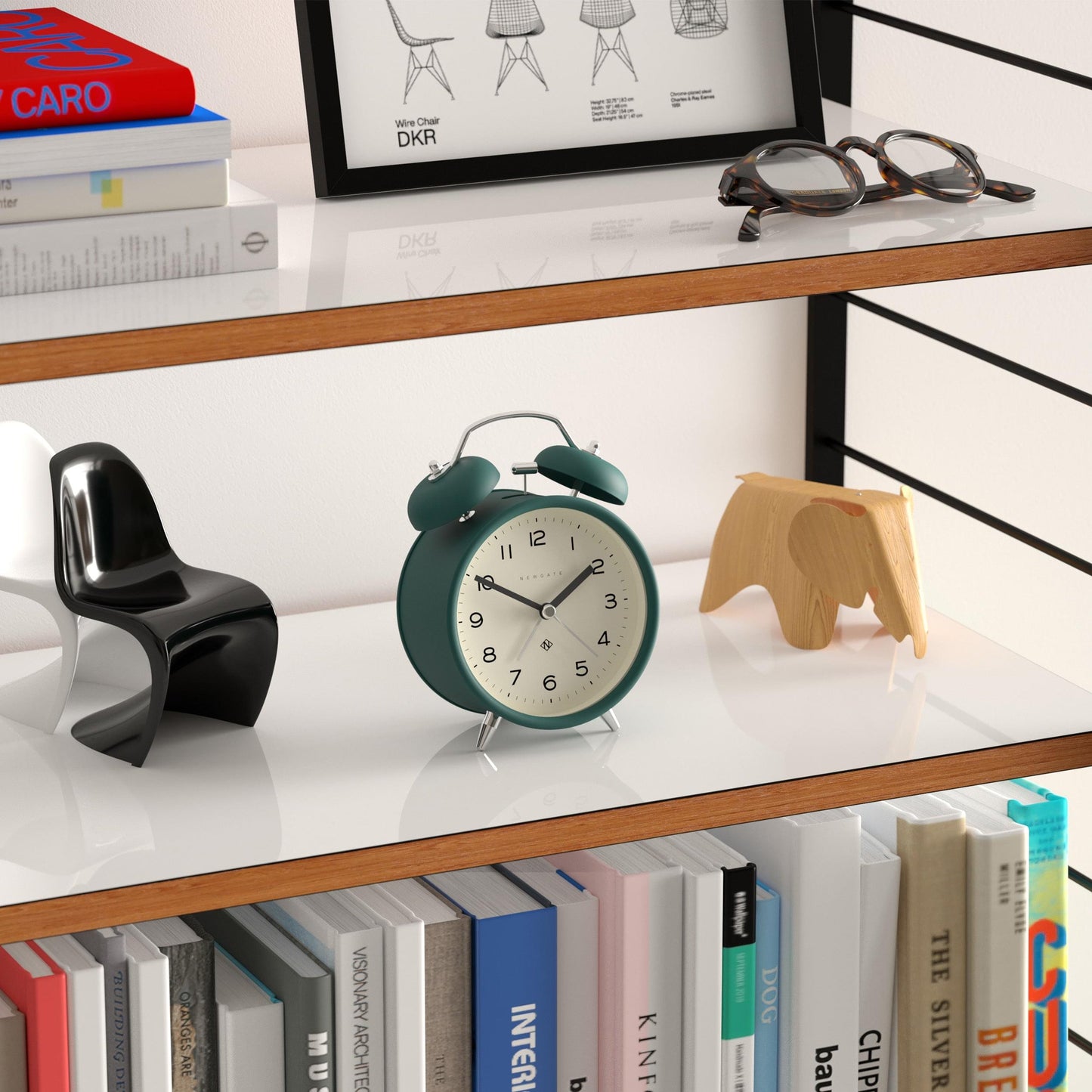 Small green twin-bell alarm clock with white dial, black hands, and silver stand