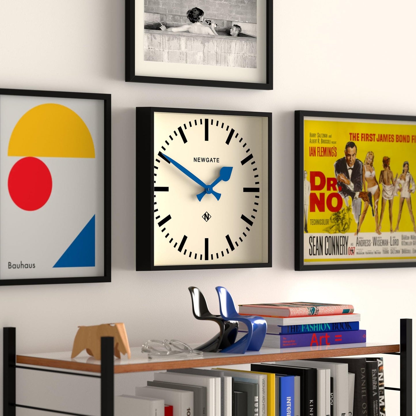 Wall clock with black frame and white dial, blue hour/minute hands and black hour markers.