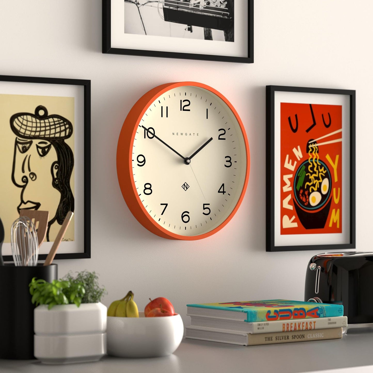 Orange wall clock, cream dial, black hands and minimalist center hub