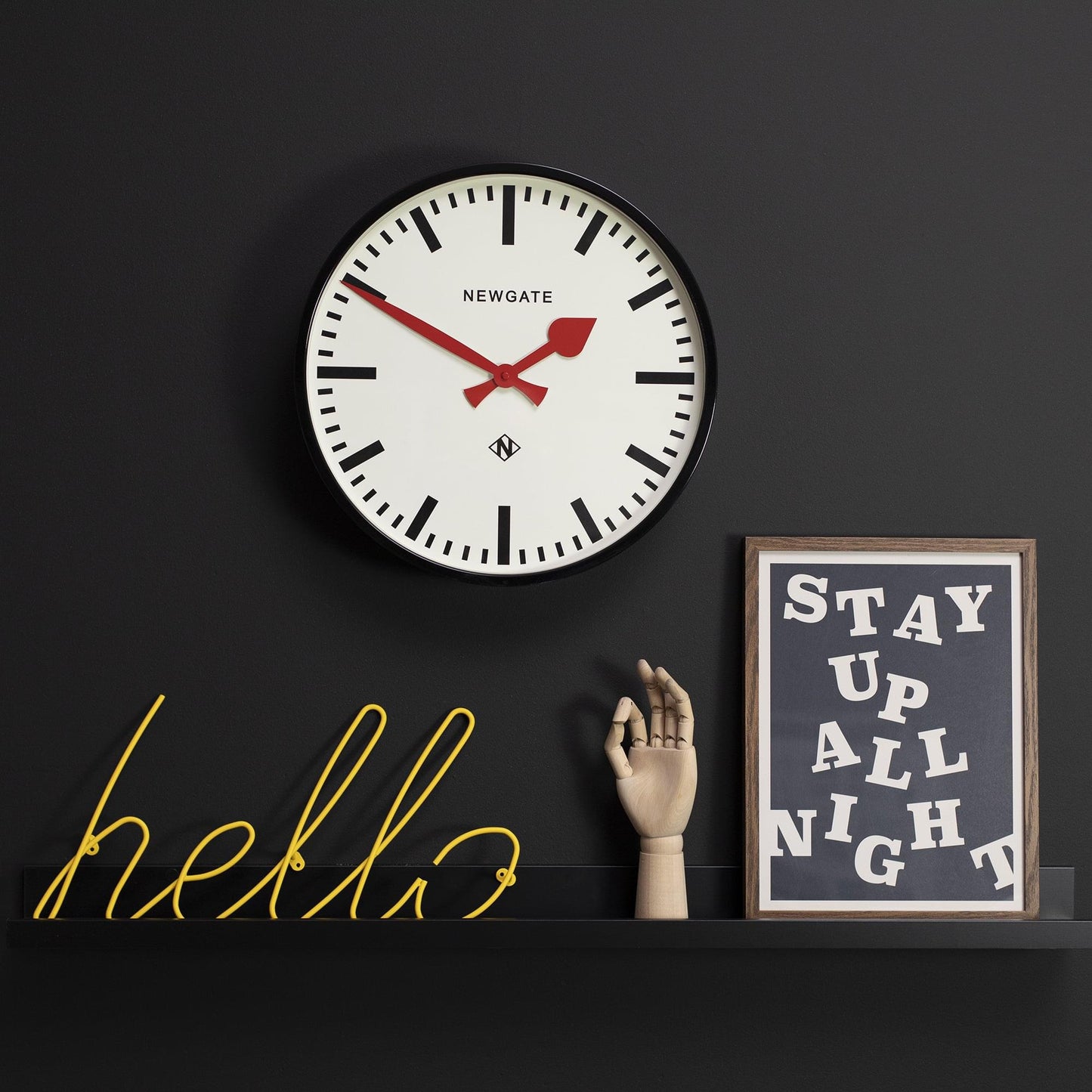 Black-bezel wall clock with white dial and red hands