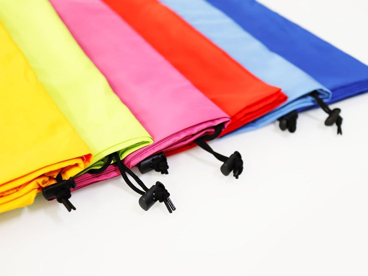 Colorful foldable drawstring laundry bags with black cord locks, stacked and closed