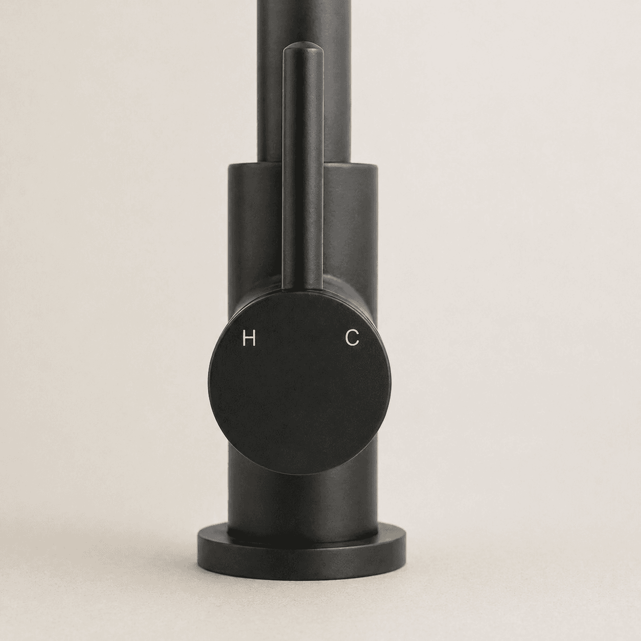 Matt black mixer tap with round temperature dial marked H and C on base