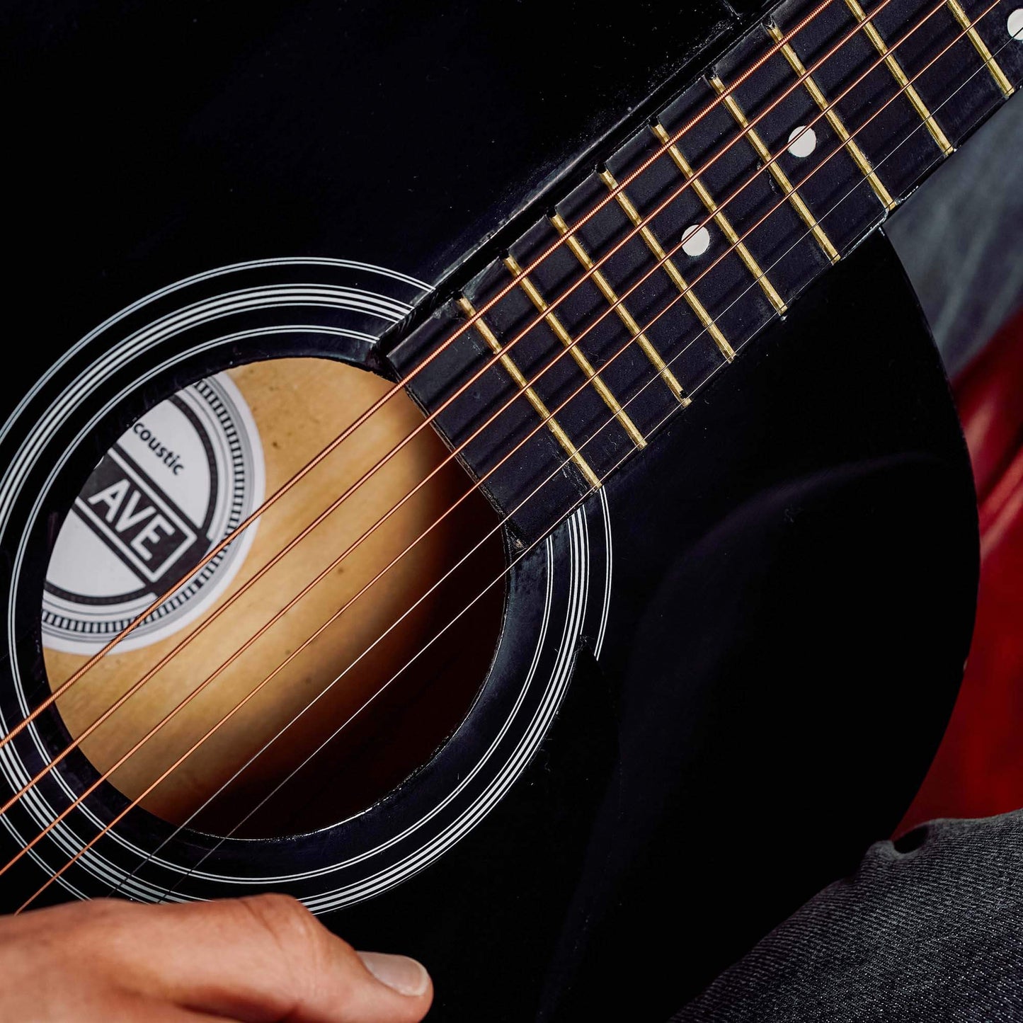 Close-up of black acoustic guitar sound hole and strings