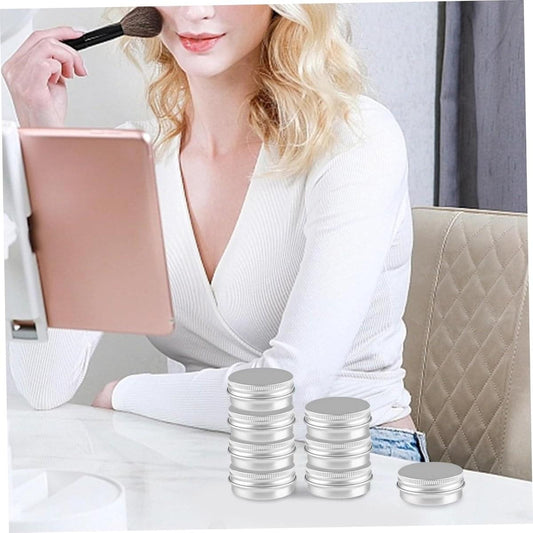 Set of small silver aluminum screw-cap tins on a table, ready for travel
