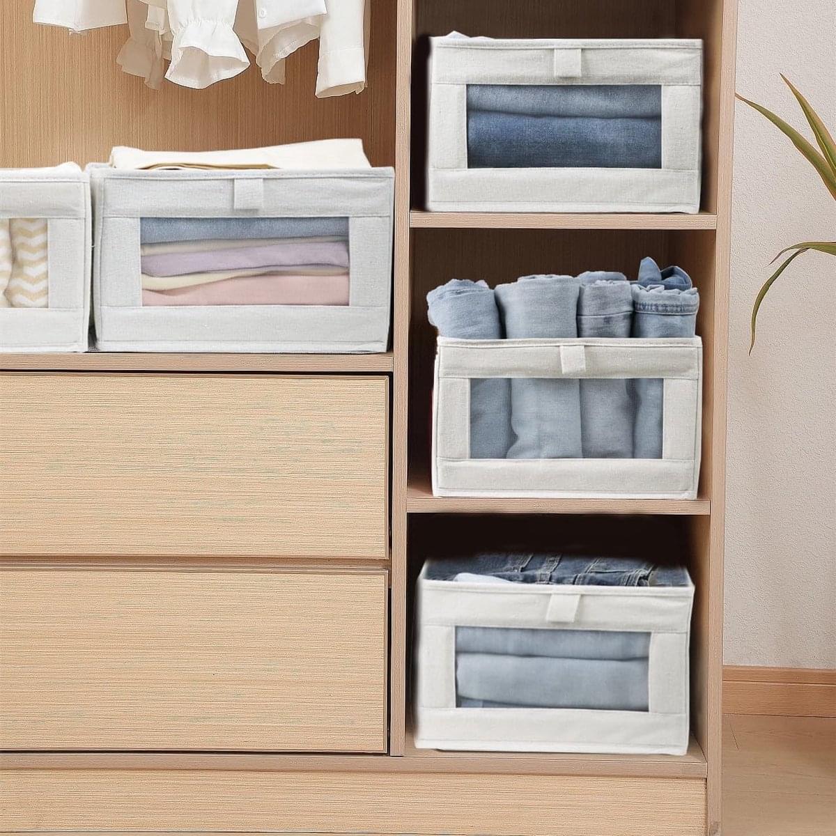 Set of fabric closet storage bins stacked with front mesh window panels