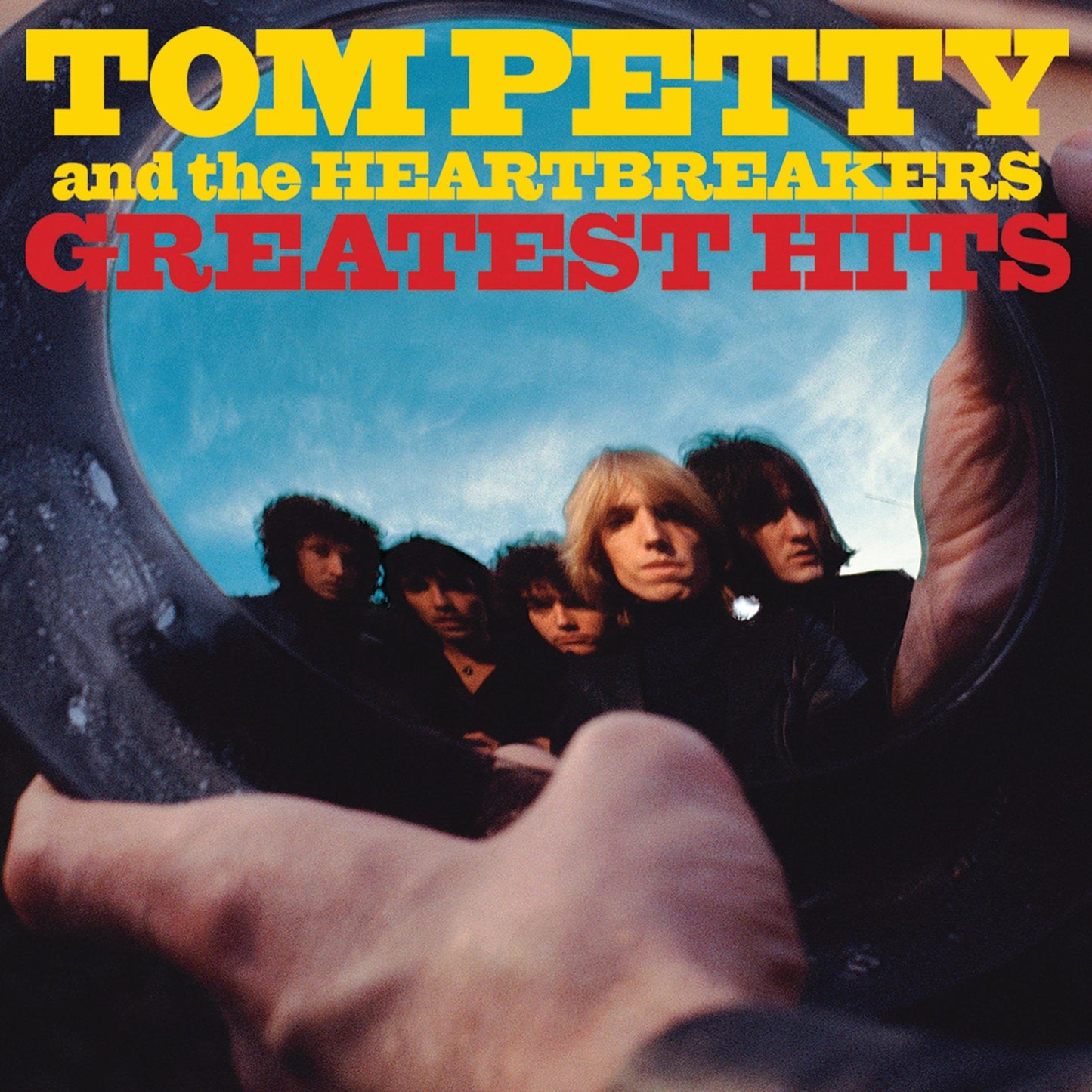 Double vinyl album cover with band portraits and bold red “Greatest Hits” title
