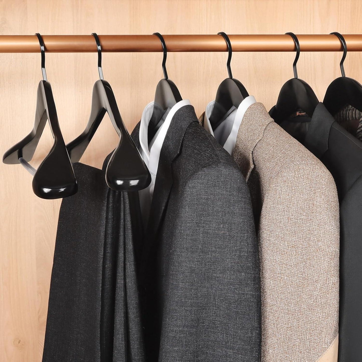 Black and charcoal wooden coat hangers on a rod, glossy wide-shoulder hooks