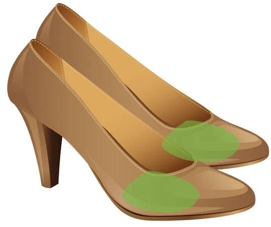 Gel ball of foot pads placed on brown high-heel shoes, green cushioning