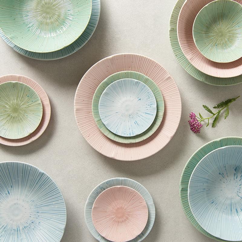 Assorted pastel glazed ceramic tapas plates with radial burst design, small round