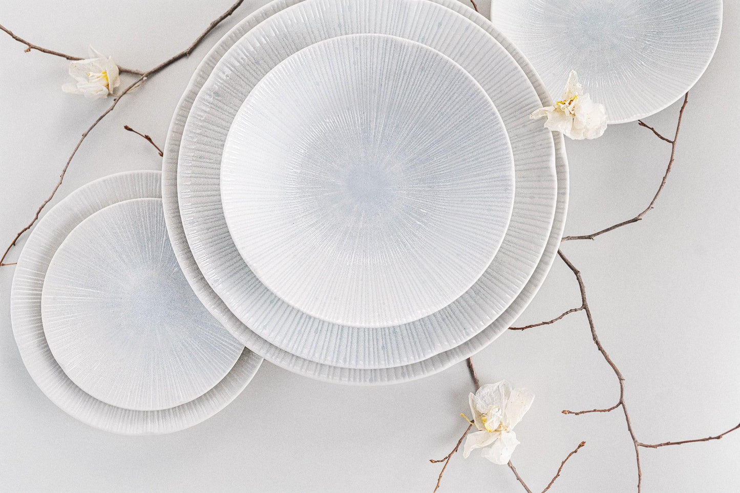 Set of ice-white tapas plates with radial textured glaze and shallow bowl shape