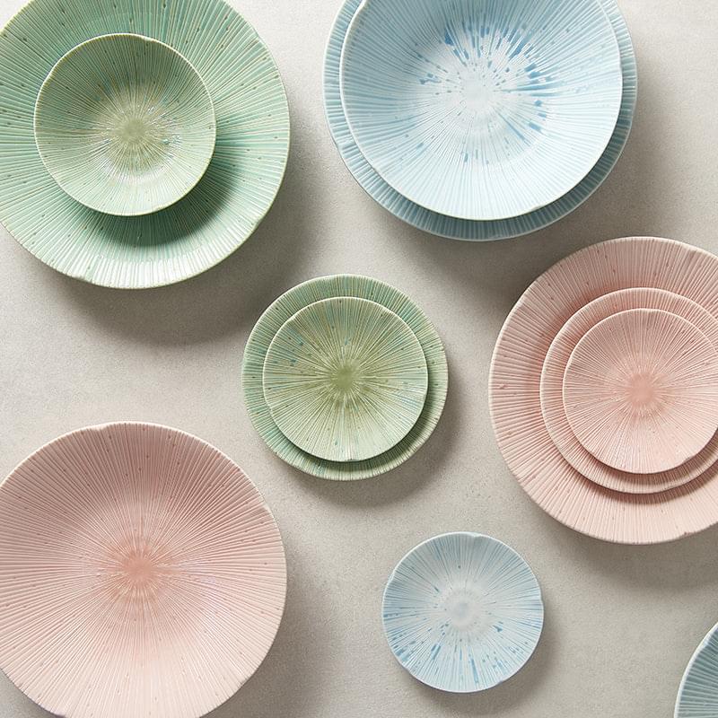 Assorted pastel tapas plates in pink, blue, and green with radial starburst design