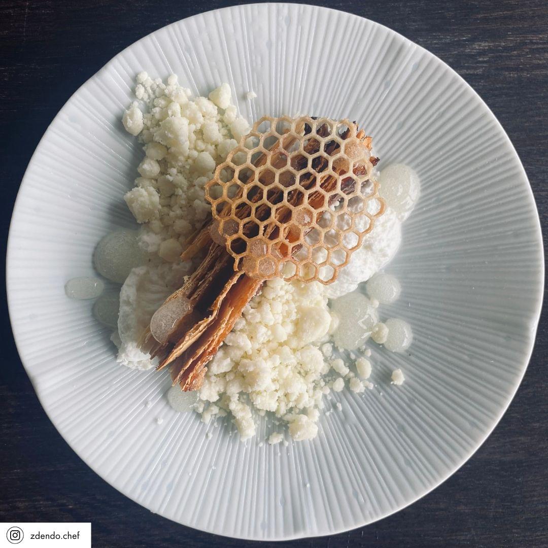Ice white tapas plate holding stacked grains and a honeycomb cracker