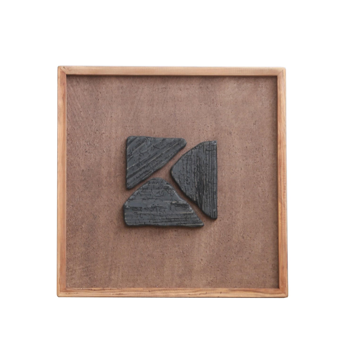 Square framed wall art with stacked dark blue geometric figures on tan texture