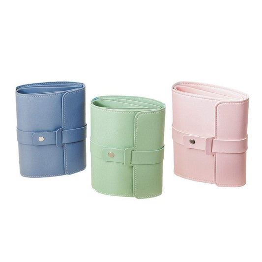 Portable jewelry storage pouches in blue, green, and pink with buckle straps