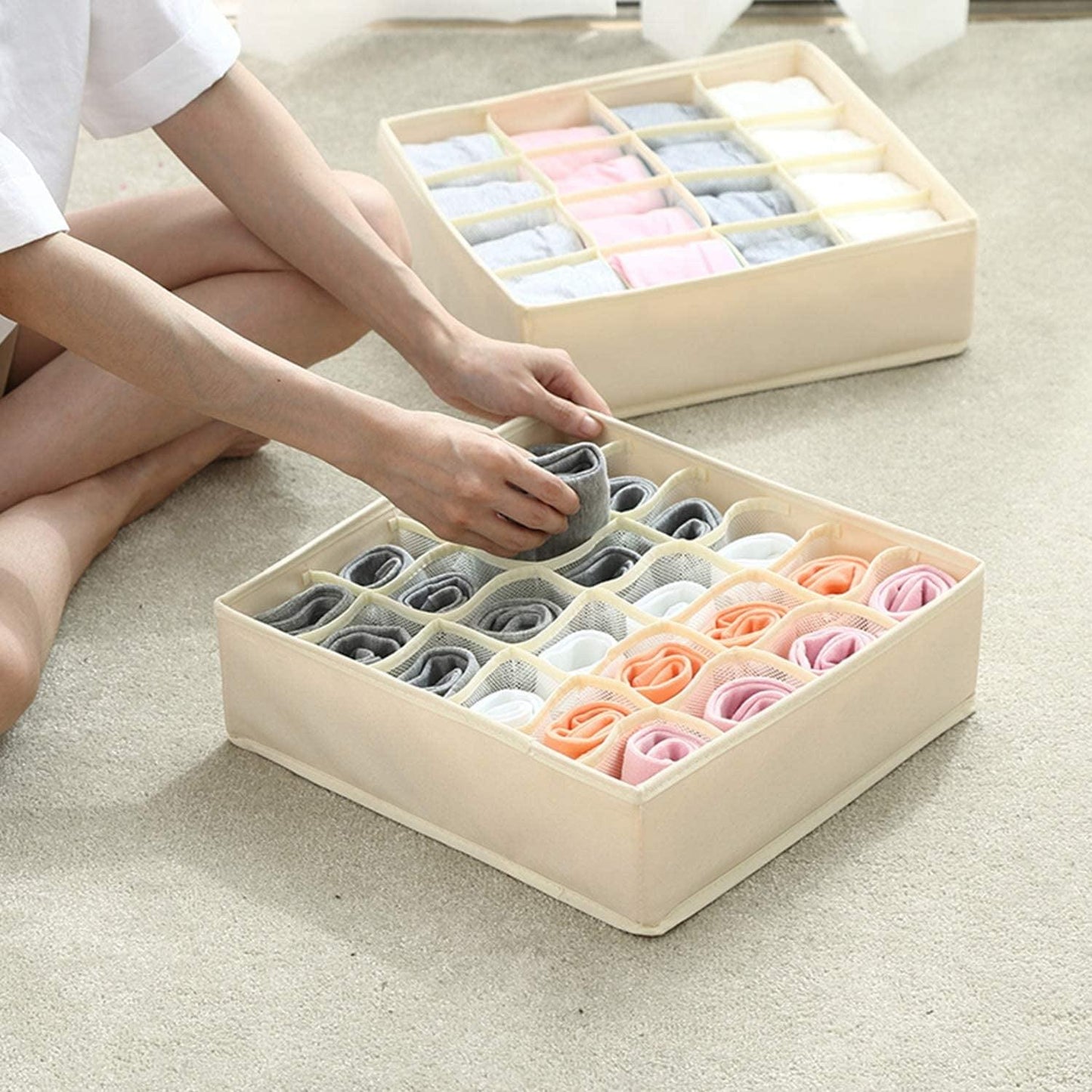 Beige 24-cell drawer organizer with dividers, shown while arranging socks