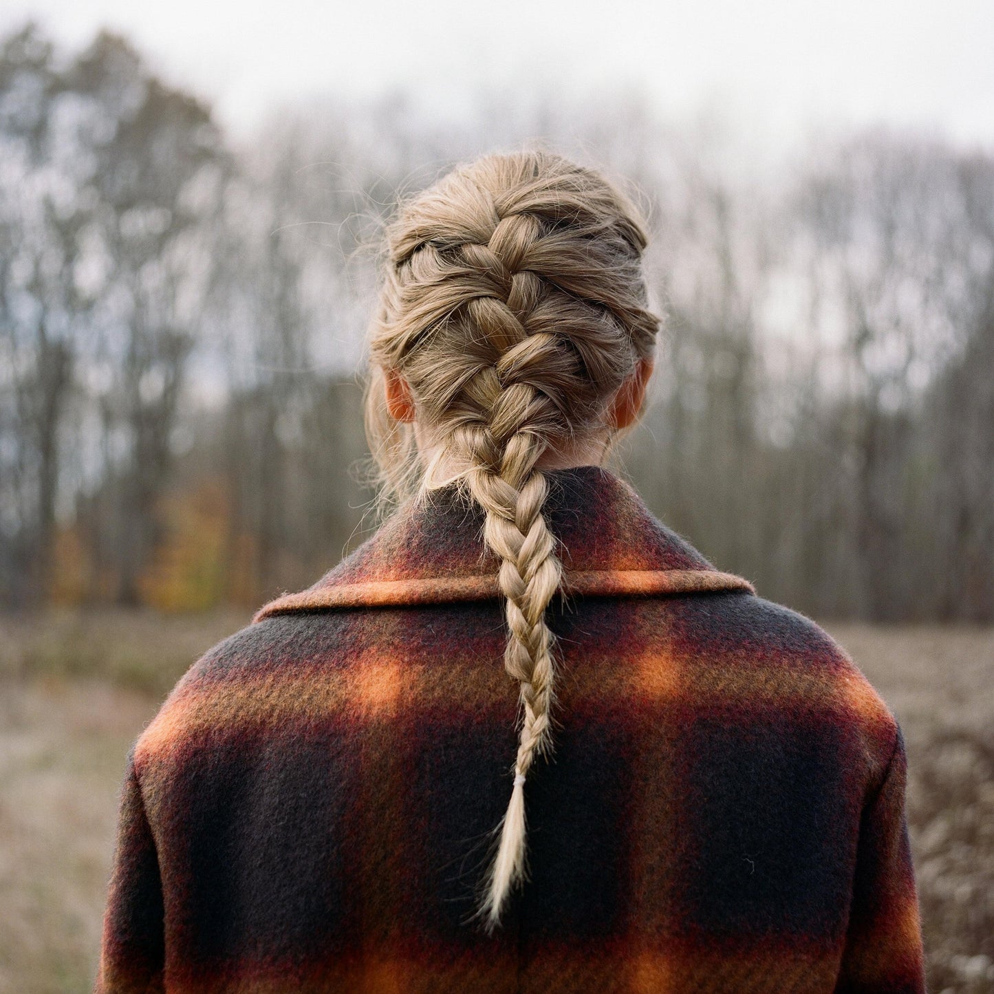 Dark wool coat with long braided hair, back view