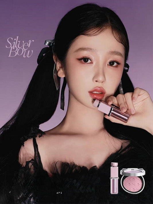 Blush and highlighter compact in pink shade with applicator held near the face