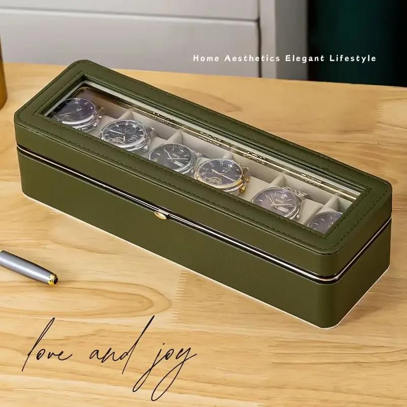 Open 6-compartment watch box with clear lid, showing watches in white lined slots