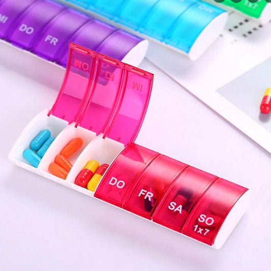 Open 7-day pill box with hinged daily compartments labeled DO, FR, SA, SO
