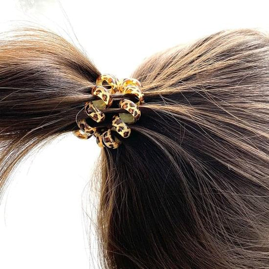 Leopard print braided hair tie holding back dark hair