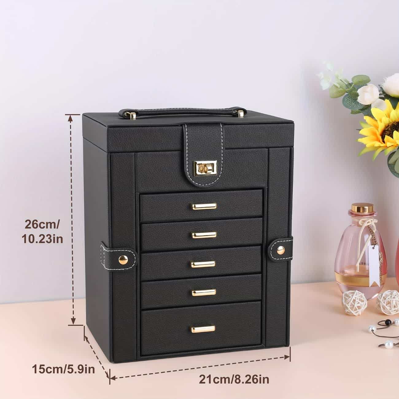 Black compact jewelry box with stacked drawers and top handle, front view with dimensions