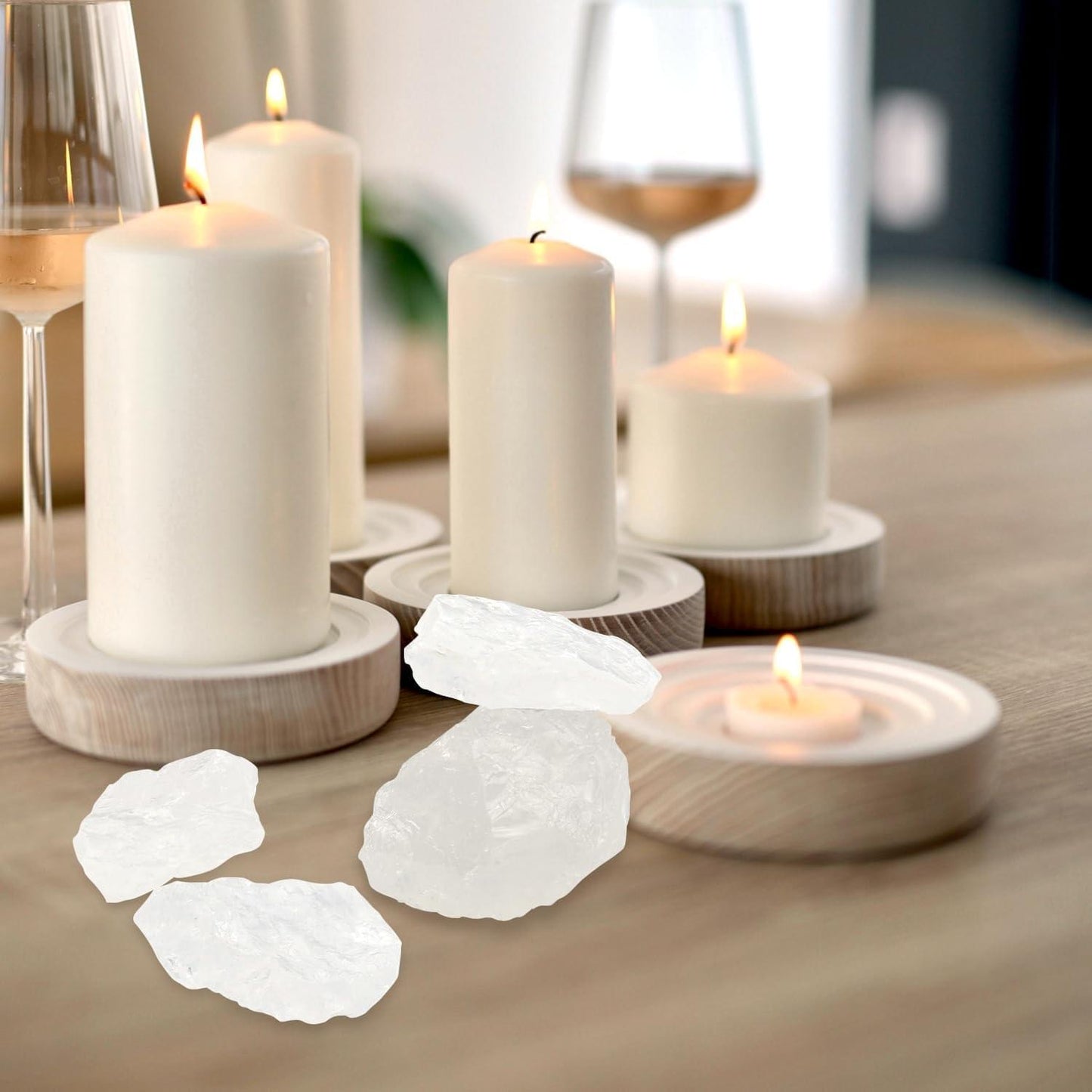 Clear quartz rough stones near candles, translucent white crystal pieces