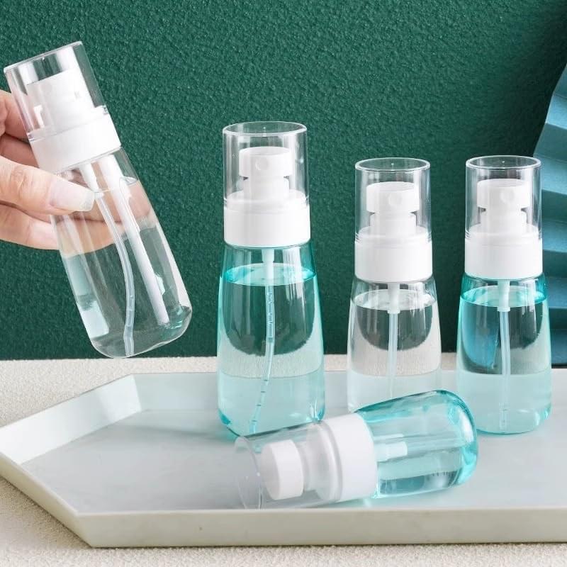 Set of refillable spray bottles with white pumps and clear bodies on tray