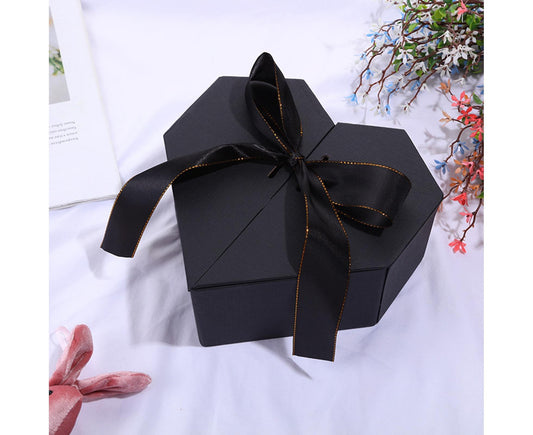 Black ribbon-tied gift box with triangular folded corners and long bow tails