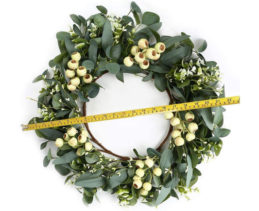 Green eucalyptus wreath with seed pods, green leaves, and measuring tape